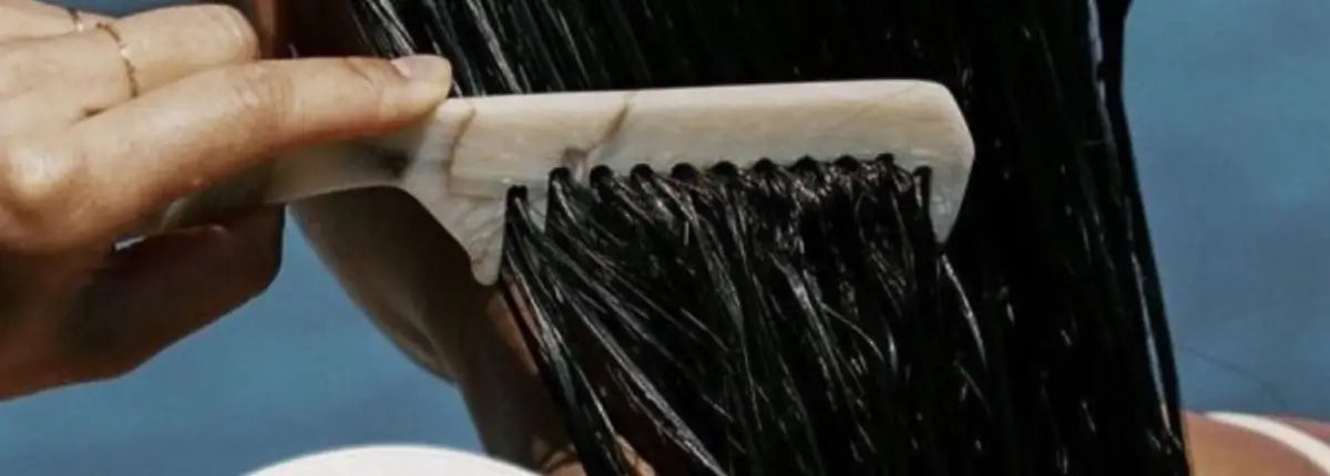Peigne démêlant des cheveux mouillés, illustrant la différence entre pellicules et psoriasis du cuir chevelu